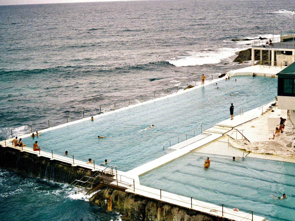 Swimmers at an ocean pool at dawn